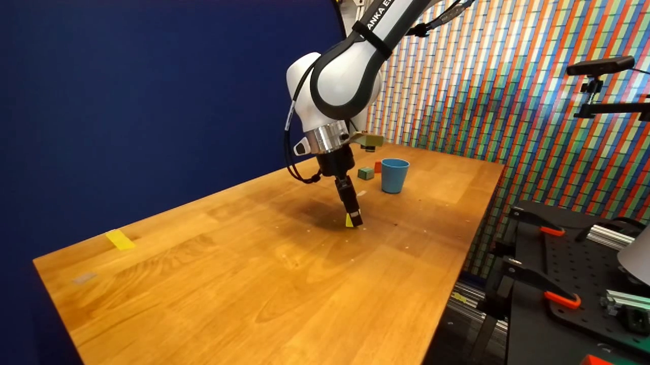 Robot gripper over a wooden tabletop